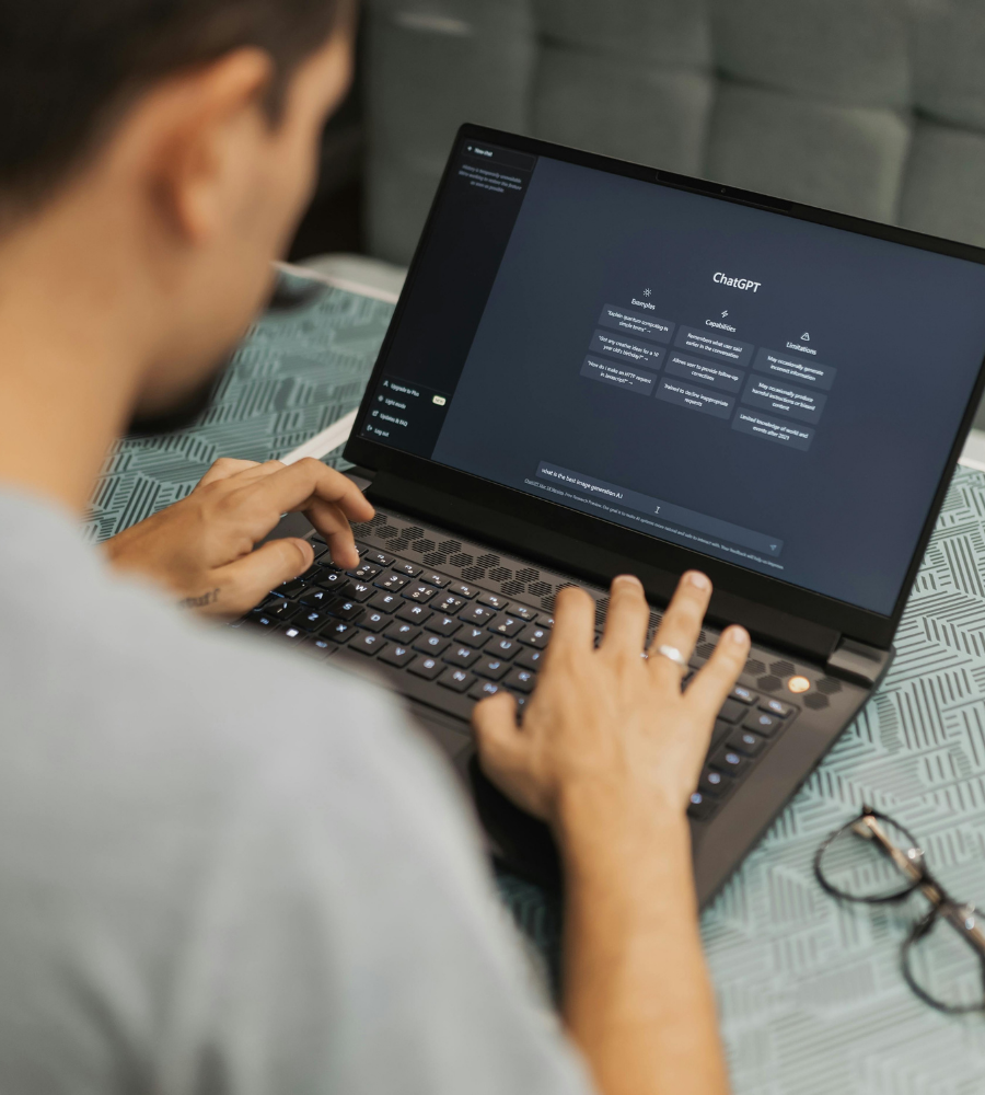 Person using a laptop with a dark-themed software interface on a patterned surface.
