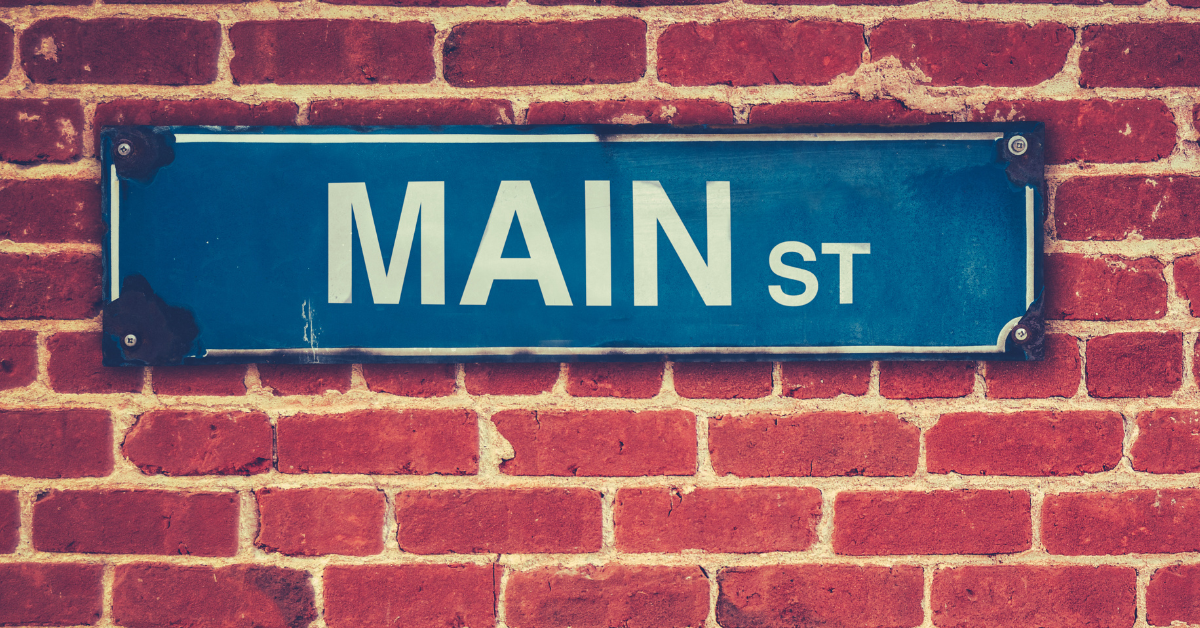 A street sign for main street on a brick wall